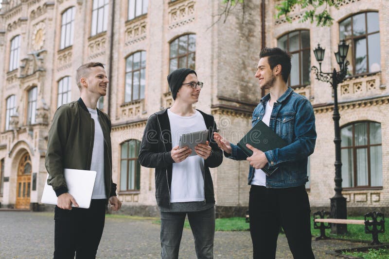 Pomyślni szczęśliwi ucznie stoi blisko kampusu lub uniwersyteta outside zdjęcia stock Pomyślni szczęśliwi ucznie stoi blisko kampusu lub uniwersyteta outside zdjęcia stock