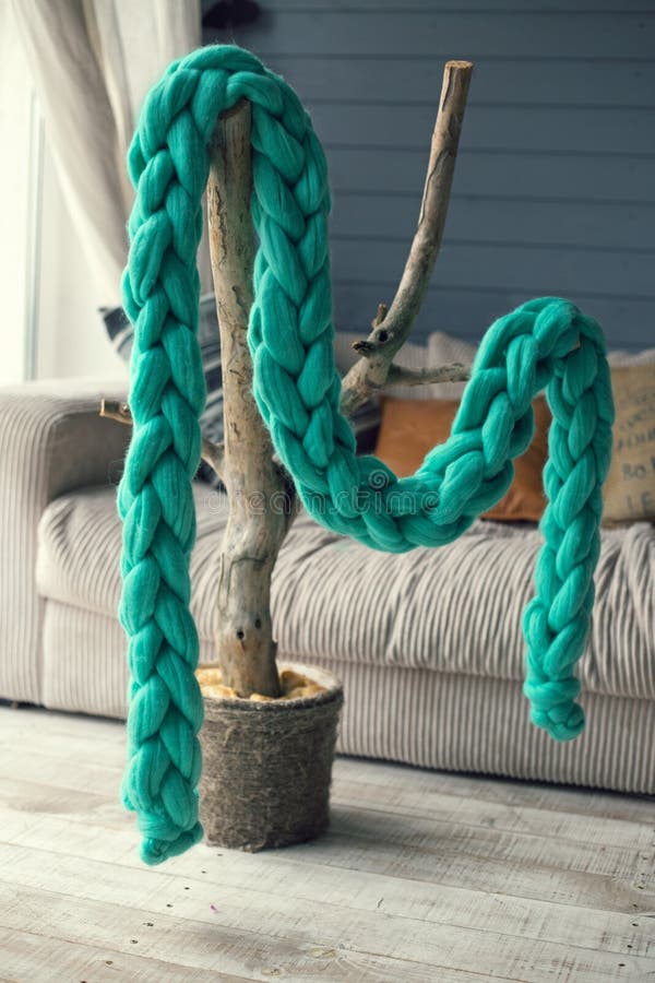 Ponga verde la bufanda hecha punto de la lana merina cuelga en un árbol artificial i imagen de archivo Ponga verde la bufanda hecha punto de la lana merina cuelga en un árbol artificial i imagen de archivo