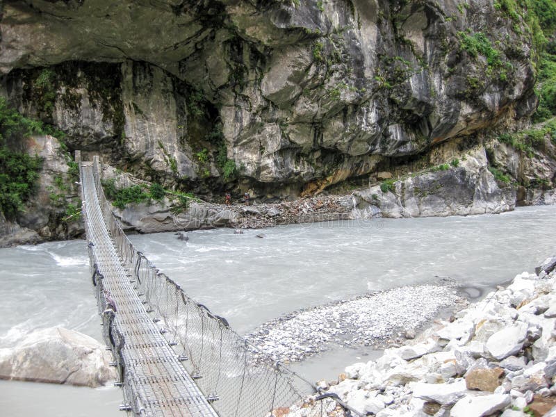 Pont au-dessus de rivière de Marsyangdi près de village de Tal - Népal image libre de droits Pont au-dessus de rivière de Marsyangdi près de village de Tal - Népal image libre de droits