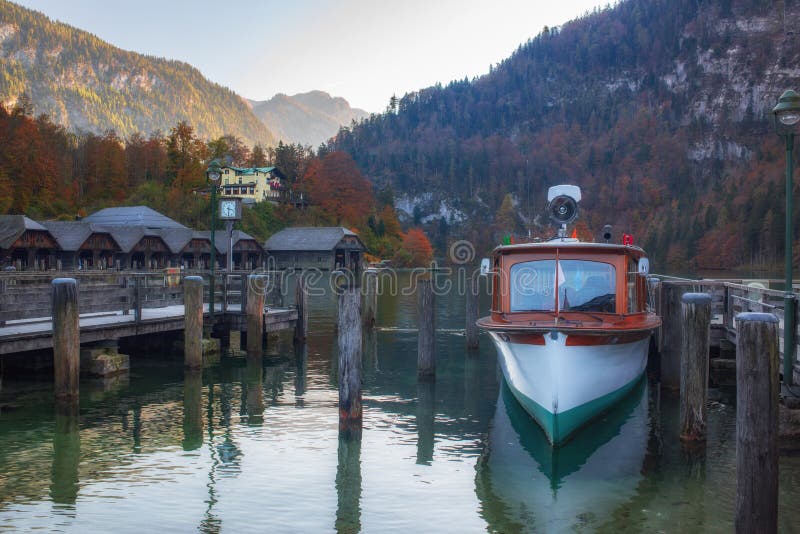 Pont en bois avec navire touristique sur le pittoresque lac de Konigssee à l'automne, Alpes de Bertechsgarden, Bavière, Allemagne image stock Pont en bois avec navire touristique sur le pittoresque lac de Konigssee à l'automne, Alpes de Bertechsgarden, Bavière, Allemagne image stock