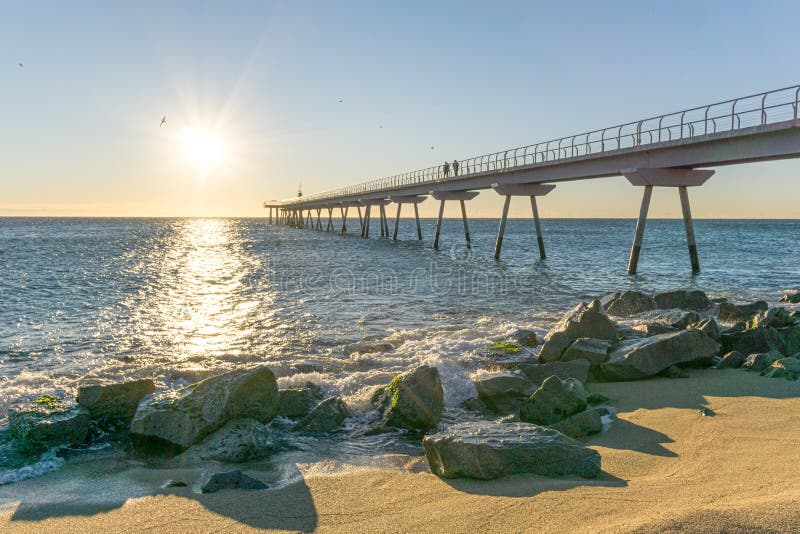 Pont maritime au lever de soleil avec des roches image stock Pont maritime au lever de soleil avec des roches image stock