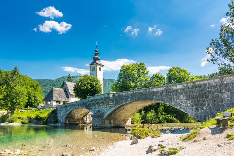 Ponte de Bohinj e igreja, Eslovênia Olhe à ponte antiga histórica velha e à igreja perto do lago Bohinj, em Triglav p nacional foto de stock Ponte de Bohinj e igreja, Eslovênia Olhe à ponte antiga histórica velha e à igreja perto do lago Bohinj, em Triglav p nacional foto de stock