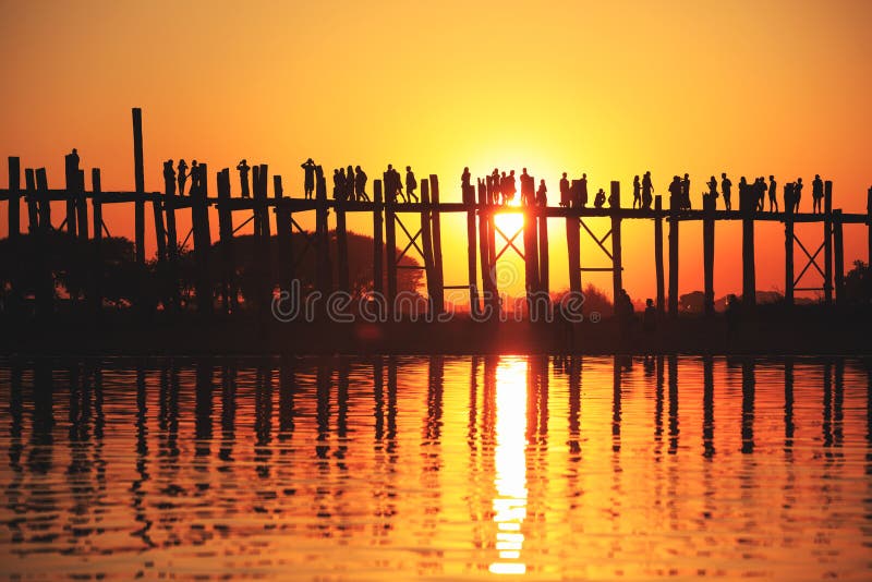 Ponte de U Bein no por do sol com os povos que cruzam o rio de Ayeyarwady, M foto de stock Ponte de U Bein no por do sol com os povos que cruzam o rio de Ayeyarwady, M foto de stock