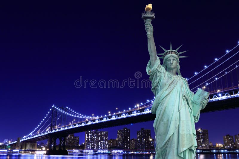 Ponte di Manhattan e la statua della libertà alla notte fotografie stock Ponte di Manhattan e la statua della libertà alla notte fotografie stock