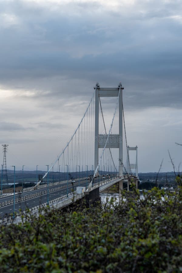 Towering suspension bridge spans across the horizon on a cloudy day, illustrating modern engineering. Towering suspension bridge spans across the horizon on a cloudy day, illustrating modern engineering