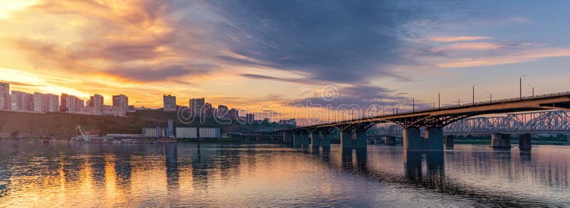 Ponte sobre o rio Yenisei, pôr do sol da noite Krasnoyarsk, Rússia panorama da cidade noturna imagem de stock Ponte sobre o rio Yenisei, pôr do sol da noite Krasnoyarsk, Rússia panorama da cidade noturna imagem de stock