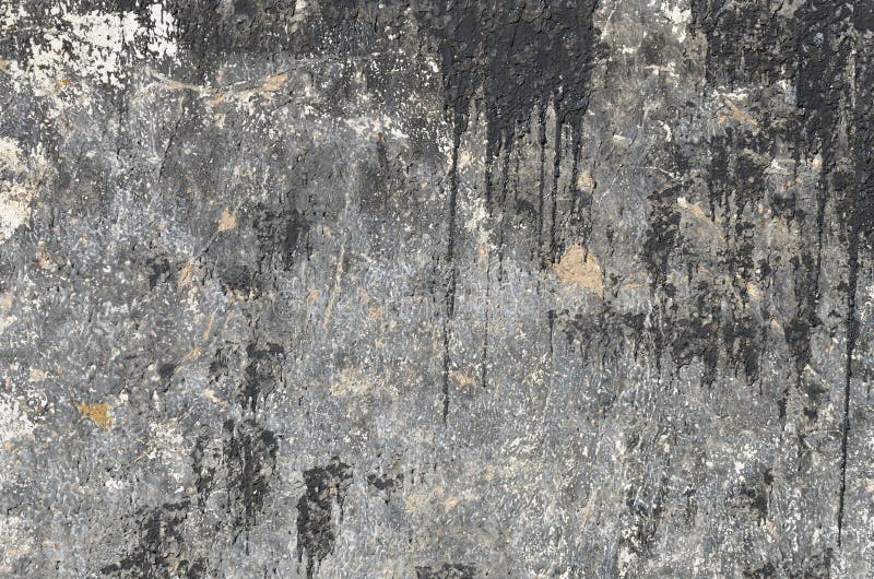 Pontos pretos e córregos do betume em um muro de cimento imagem de stock Pontos pretos e córregos do betume em um muro de cimento imagem de stock