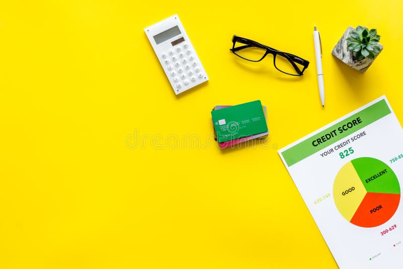 Pontuação de crédito com cartões de crédito e calculadora, vidros na zombaria amarela da opinião superior do fundo do lugar de tr