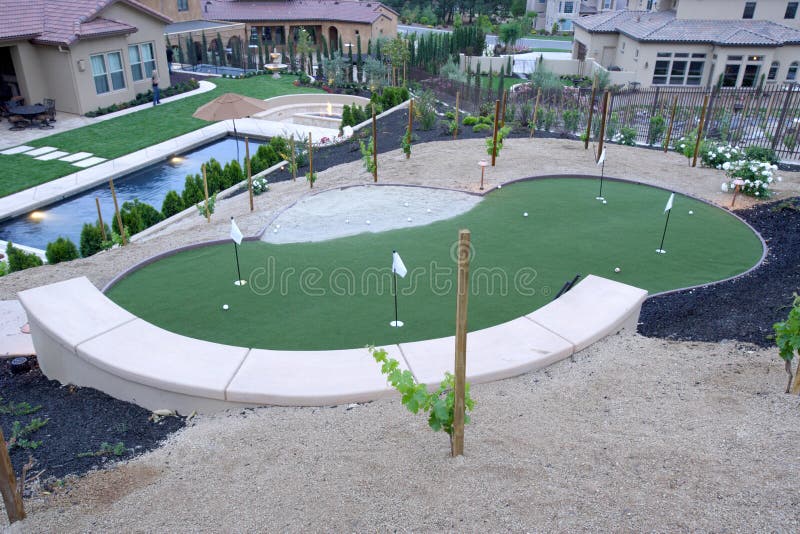 A pool with a waterfall in a luxury backyard