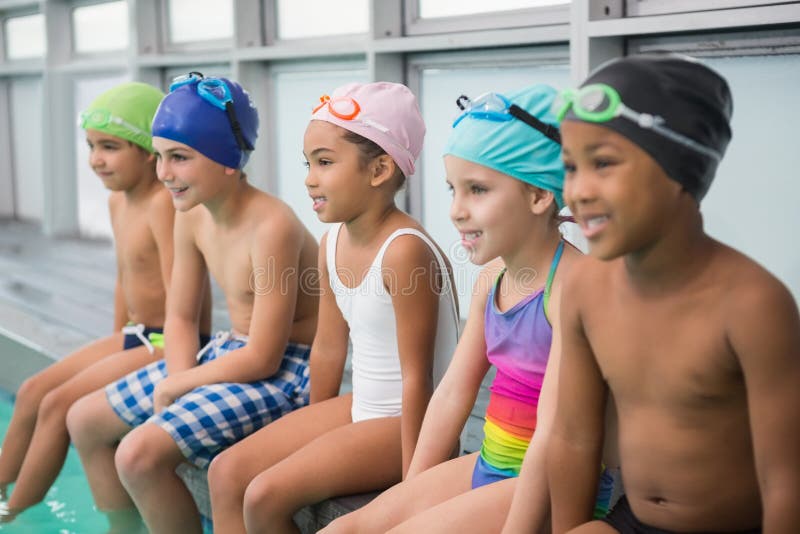 Poolside de sourire de classe mignonne de natation photographie stock Poolside de sourire de classe mignonne de natation photographie stock