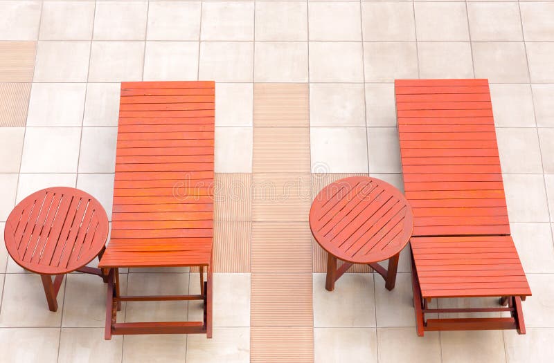Poolside deckchairs alongside blue swimming pool from top view royalty free stock images