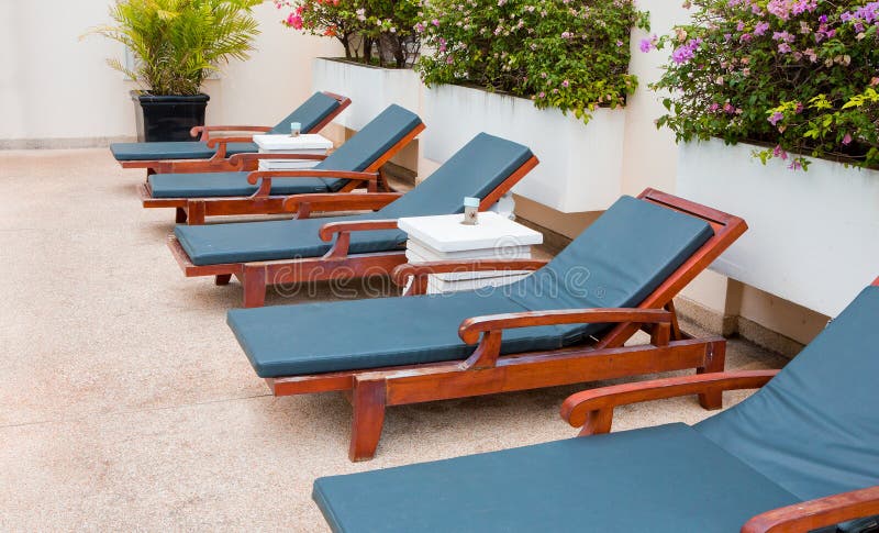 Poolside deckchairs with blue swimming pool royalty free stock images