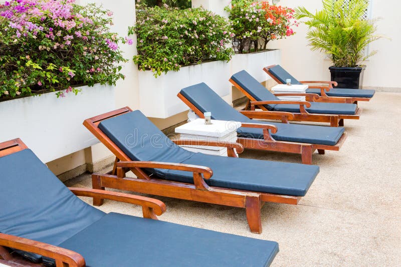Poolside deckchairs blue swimming pool stock photo