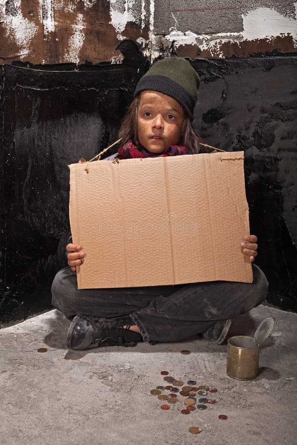 Poor beggar boy on the street with a cardboard sign royalty free stock photo Poor beggar boy on the street with a cardboard sign royalty free stock photo