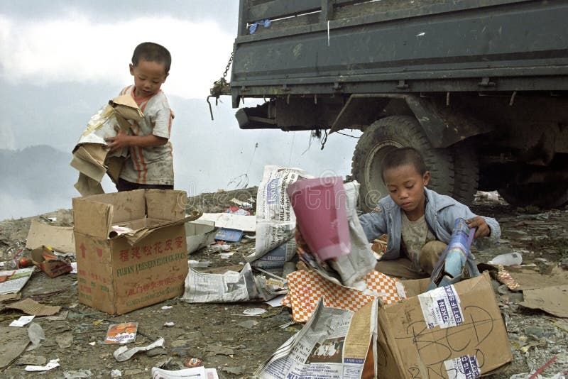 Poor Filipino boys gathering old paper on landfill