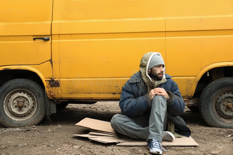 Poor homeless man sitting near van royalty free stock photos