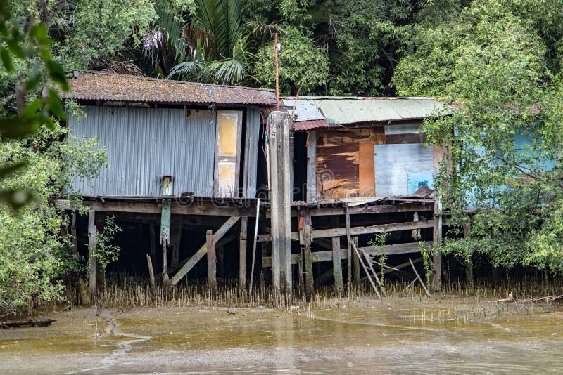 Poor houses on the muddy river bank.