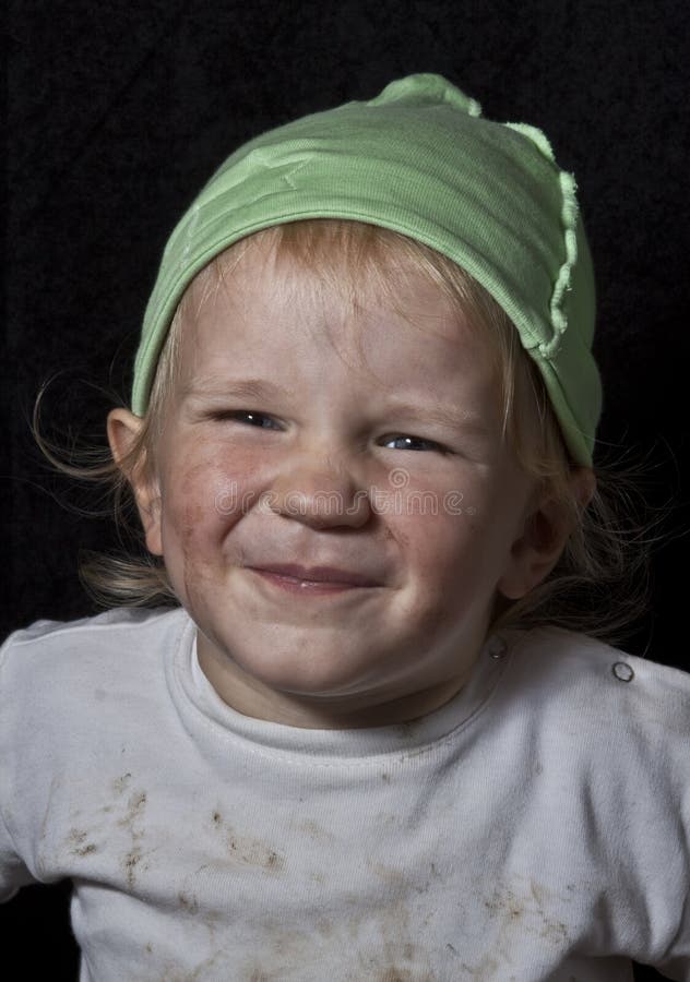 Poor laughing child on black background