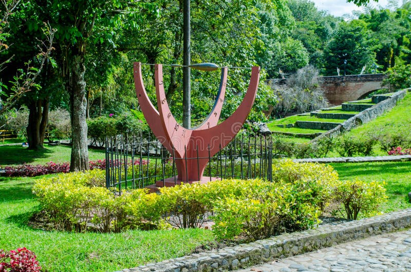 POPAYAN, COLOMBIA - MARCH 31, 2018: Outdoor view of tourists walking in the park, with a orantge matllic structure with