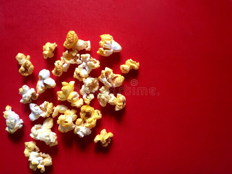 Popcorn con sapore del burro e del formaggio su fondo rosso fotografia stock Popcorn con sapore del burro e del formaggio su fondo rosso fotografia stock