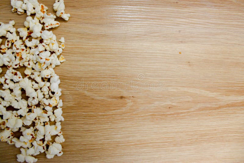Popcorn die op houten achtergrond wordt geschikt stock afbeeldingen Popcorn die op houten achtergrond wordt geschikt stock afbeeldingen
