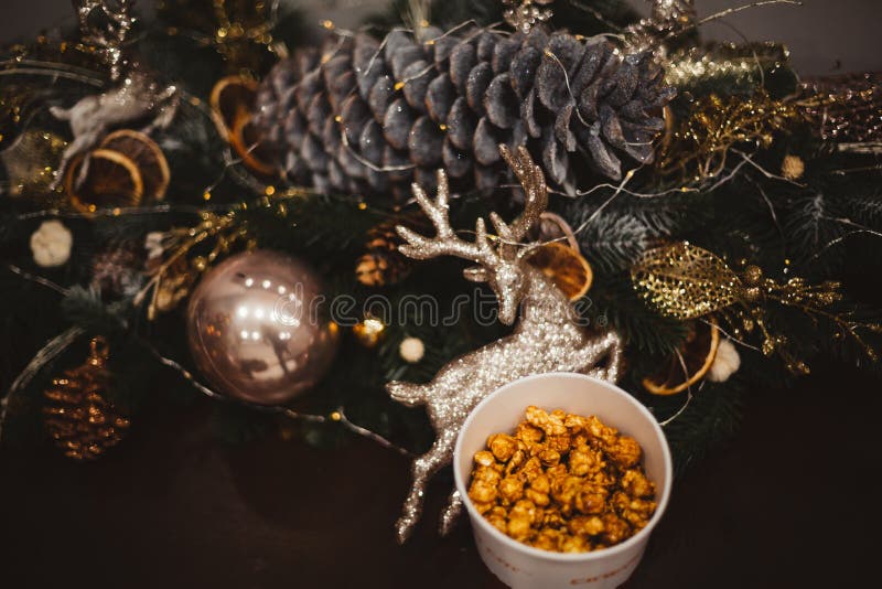 Popcorn in einer hölzernen Platte auf dem Hintergrund von Weihnachtsbäumen und von Weihnachtsdekorationen, Angebot des neuen Jahr lizenzfreies stockbild Popcorn in einer hölzernen Platte auf dem Hintergrund von Weihnachtsbäumen und von Weihnachtsdekorationen, Angebot des neuen Jahr lizenzfreies stockbild