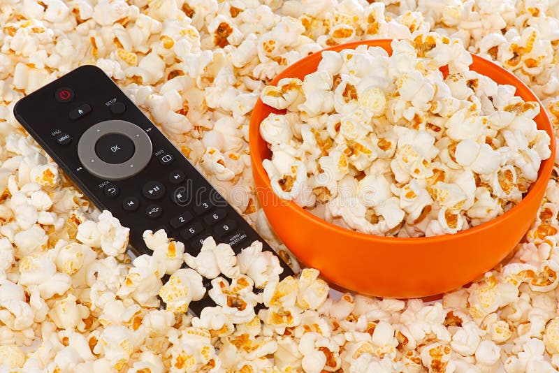 Popcorn in a orange bowl and remote control