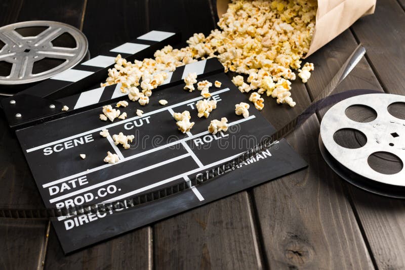 Popcorn in paper container and movie clapper board on table, Movie time concept stock images Popcorn in paper container and movie clapper board on table, Movie time concept stock images