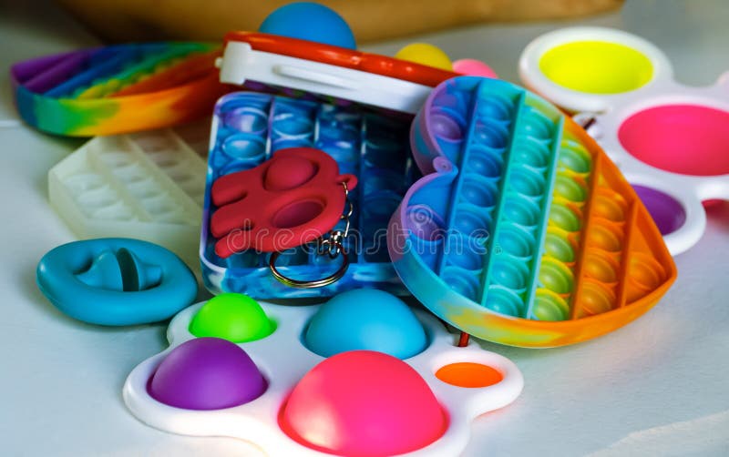 Popit and simple dimple toys on white table. Closeup.