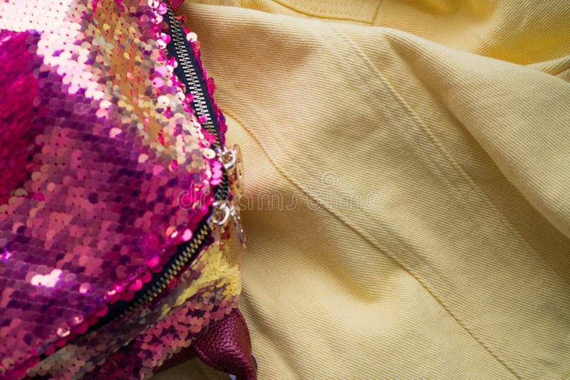 Popolare gialli del tessuto del denim in primo piano e tessuto con gli zecchini rosa luminosi Fondo luminoso di estate per le ins fotografie stock Popolare gialli del tessuto del denim in primo piano e tessuto con gli zecchini rosa luminosi Fondo luminoso di estate per le ins fotografie stock