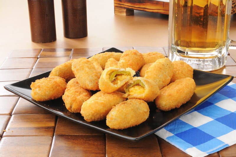 Jalapeno and cheddar cheese poppers with a mug of beer. Jalapeno and cheddar cheese poppers with a mug of beer