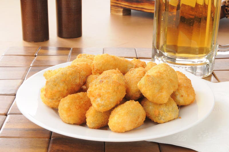 A plate of poppers with a mug of beer. A plate of poppers with a mug of beer