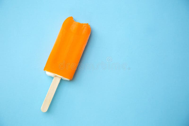 Orange popsicle on a blue background. Orange popsicle on a blue background