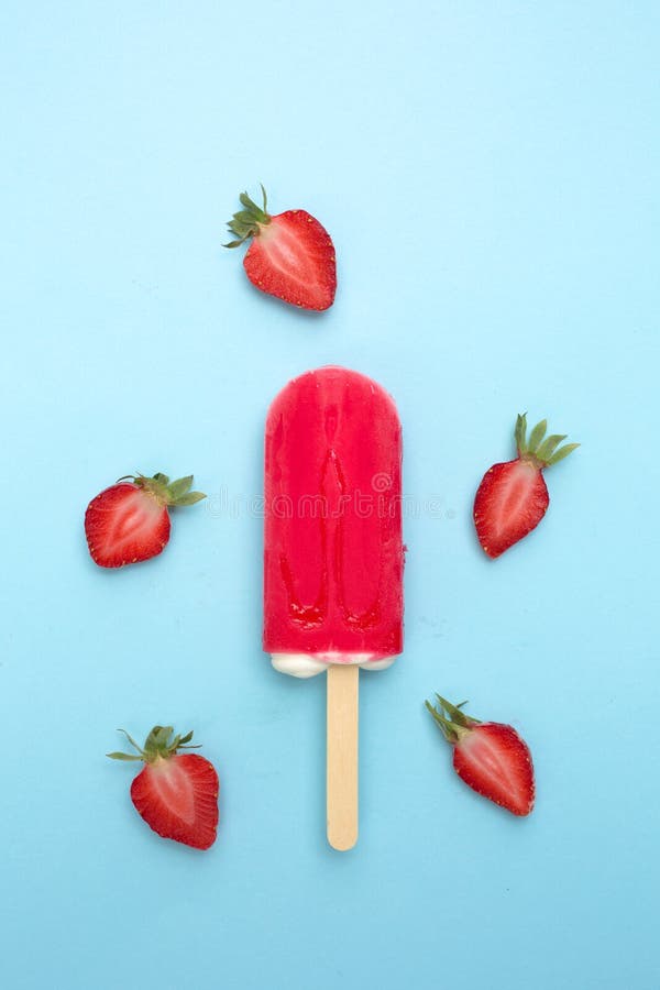 Strawberry popsicle with fresh strawberry on a blue background. Strawberry popsicle with fresh strawberry on a blue background