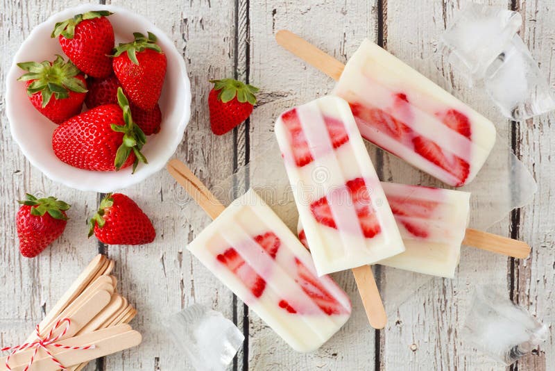 Popsicles домодельной клубники ванильные на деревенской белой древесине стоковые изображения