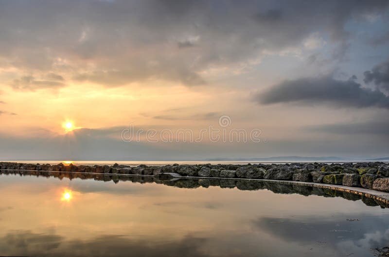Por do sol acima de uma associação na praia imagens de stock royalty free Por do sol acima de uma associação na praia imagens de stock royalty free