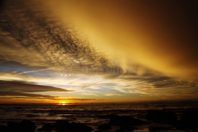 Por do sol após a chuva pesada com as nuvens e as pedras de tempestade da prateleira do arcus no oceano na ilha tropical Ko Lanta foto de stock royalty free Por do sol após a chuva pesada com as nuvens e as pedras de tempestade da prateleira do arcus no oceano na ilha tropical Ko Lanta foto de stock royalty free
