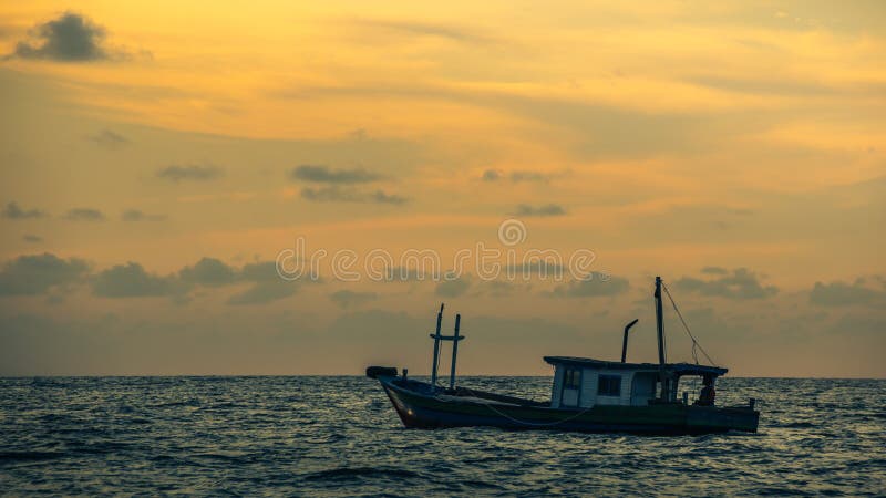 Por do sol bonito com barco de pesca imagem de stock Por do sol bonito com barco de pesca imagem de stock