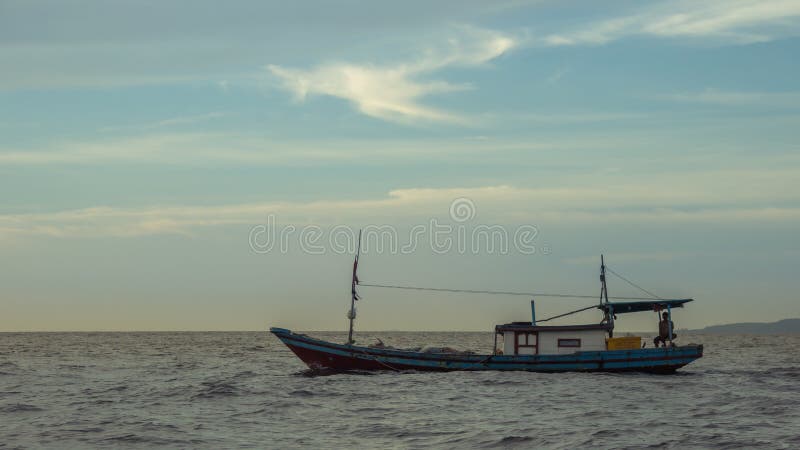 Por do sol bonito com barco de pesca imagem de stock Por do sol bonito com barco de pesca imagem de stock