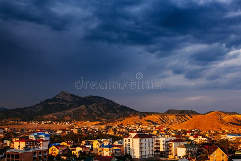 Por do sol bonito na noite e montanhas perto da cidade imagens de stock Por do sol bonito na noite e montanhas perto da cidade imagens de stock