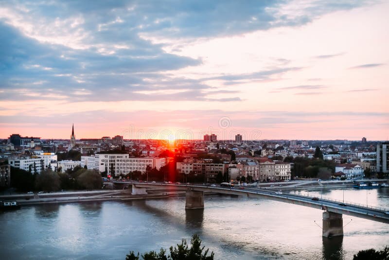 Por do sol bonito sobre Danube River e cidade de Novi Sad com ponte do arco-íris fotos de stock Por do sol bonito sobre Danube River e cidade de Novi Sad com ponte do arco-íris fotos de stock