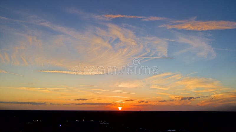 Por do sol com as nuvens coloridas de fluxo imagem de stock royalty free Por do sol com as nuvens coloridas de fluxo imagem de stock royalty free