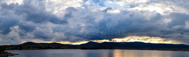 Por do sol de Jindabyne do lago em um dia nublado, nebuloso imagens de stock Por do sol de Jindabyne do lago em um dia nublado, nebuloso imagens de stock