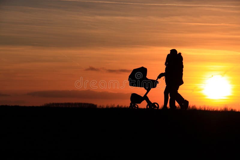 Por do sol de passeio do carro de bebê dos pares imagens de stock royalty free Por do sol de passeio do carro de bebê dos pares imagens de stock royalty free