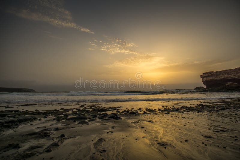 Por do sol em uma praia imagem de stock royalty free Por do sol em uma praia imagem de stock royalty free