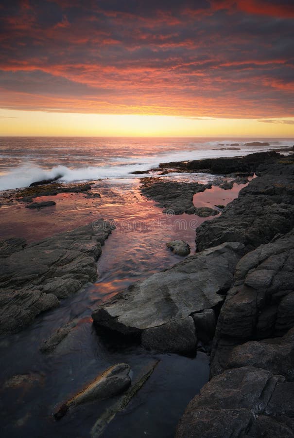 Por do sol sobre o litoral rochoso foto de stock Por do sol sobre o litoral rochoso foto de stock