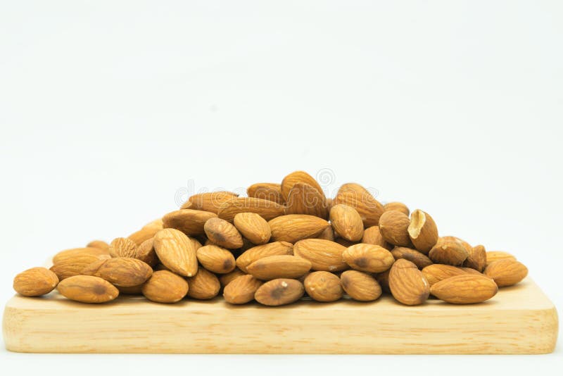 Porca marrom crua da amêndoa na placa de madeira foto de stock royalty free