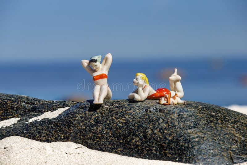 Porcelan postacie sunbathing dziewczyny na granitu kamieniu zdjęcia royalty free Porcelan postacie sunbathing dziewczyny na granitu kamieniu zdjęcia royalty free