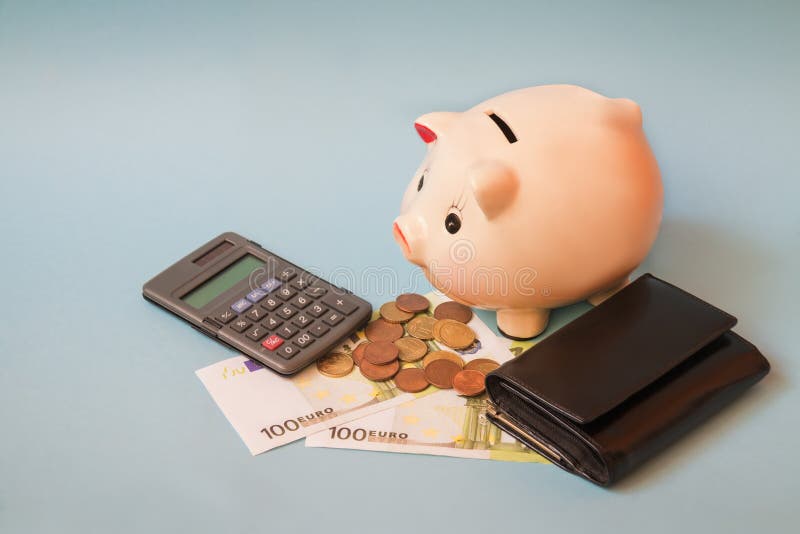 Porcellino salvadanaio con le euro banconote e monete, borsa e calcolatore su fondo blu fotografie stock Porcellino salvadanaio con le euro banconote e monete, borsa e calcolatore su fondo blu fotografie stock