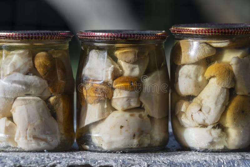Porcini mushrooms canned in a glass jar for sale at the local market, Western Ukraine, close up